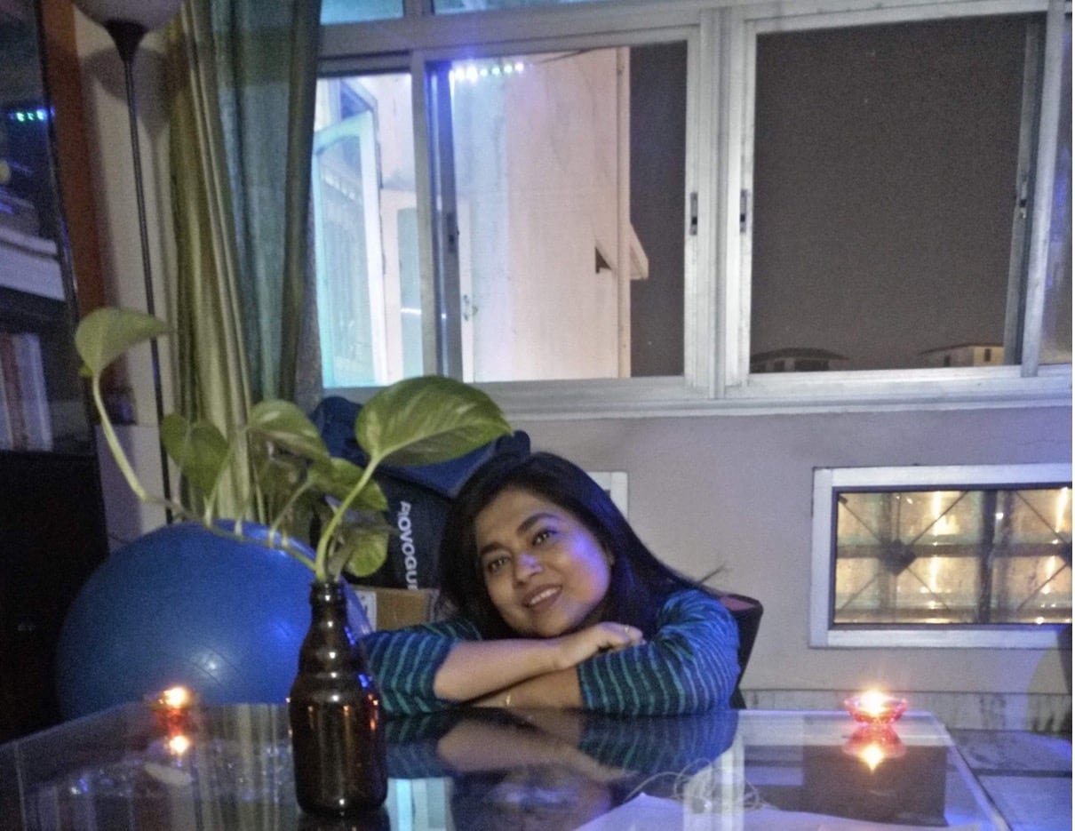 default-176 A woman sitting at a clear kitchen table with large windows in the background.