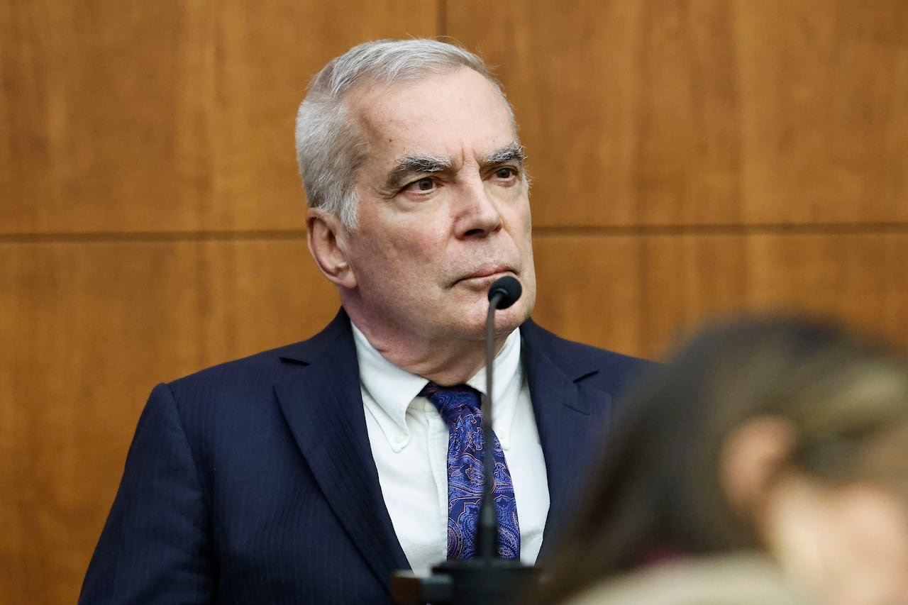 default-1656 Serious-looking grey-haired man in a blue suit testifying in court